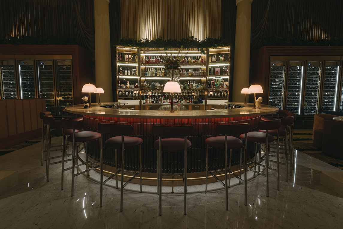 Elegant interior of Brasserie Astoria Singapore featuring a grand circular bar, perfect for Golden Hour happy hour cocktails.