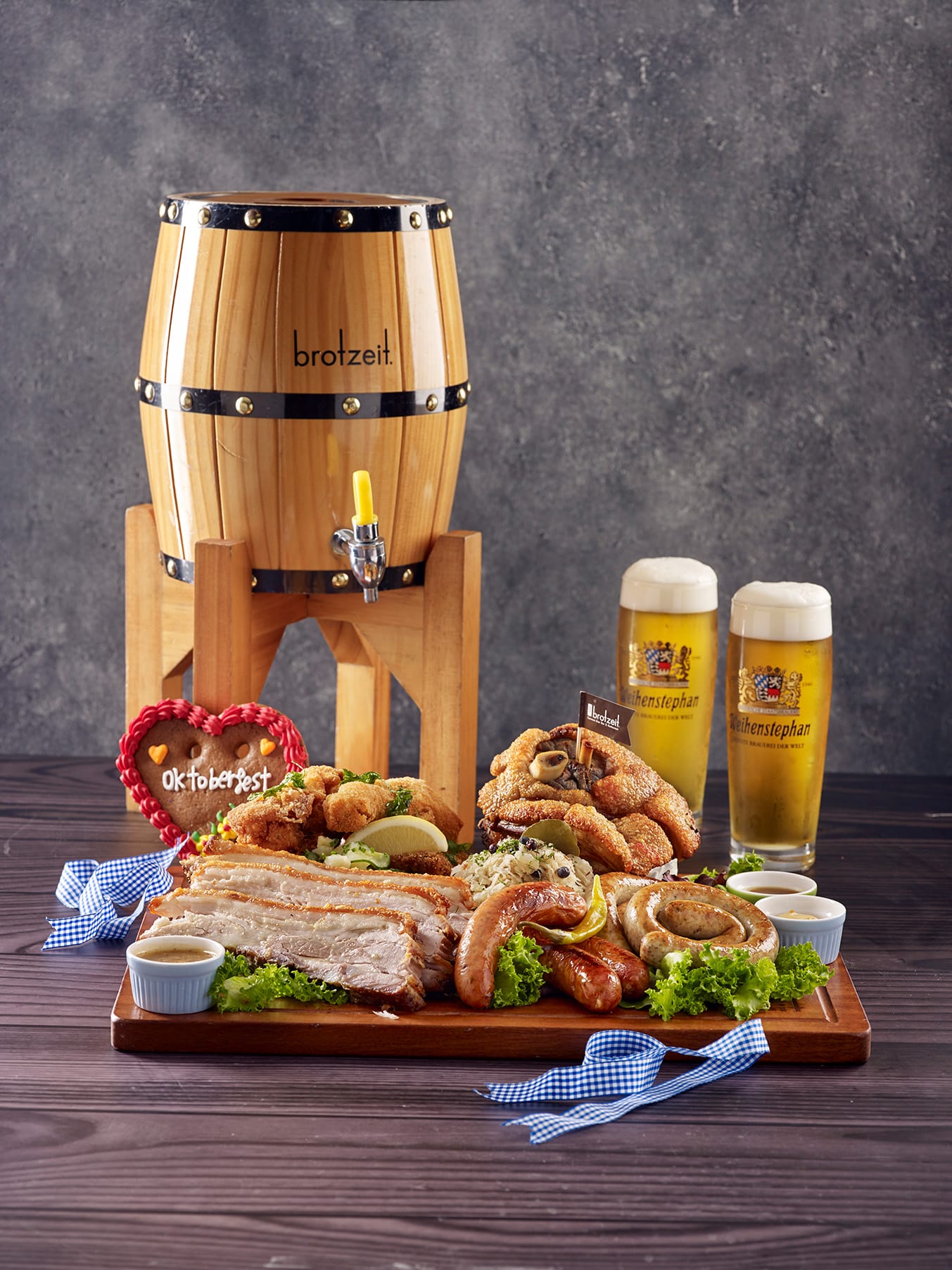 Brotzeit Oktoberfest 2025 platter in Singapore featuring pork knuckle, sausages, pretzels, and Weihenstephaner Festbier served with a mini beer barrel.