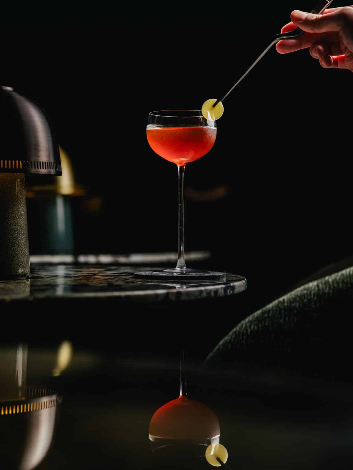 Signature cocktail at CODA bar in Robertson Quay, showcasing refined mixology with Asian spirits in a minimalist lounge setting.