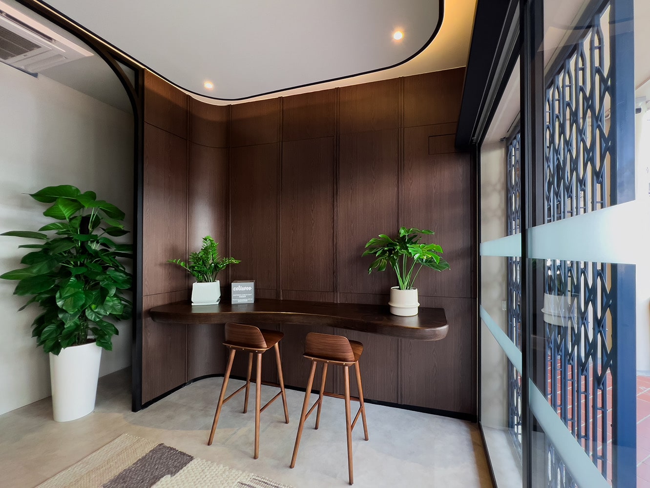 Coliwoo Kampong Glam hotel reception area in Singapore, featuring warm wooden interiors and street-facing café-style seating