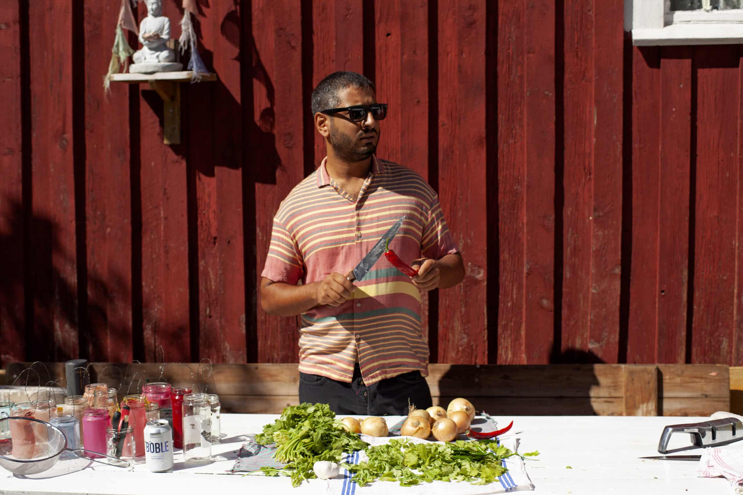 Marco Antão standing behind a kitchen counter packed with ingredients.