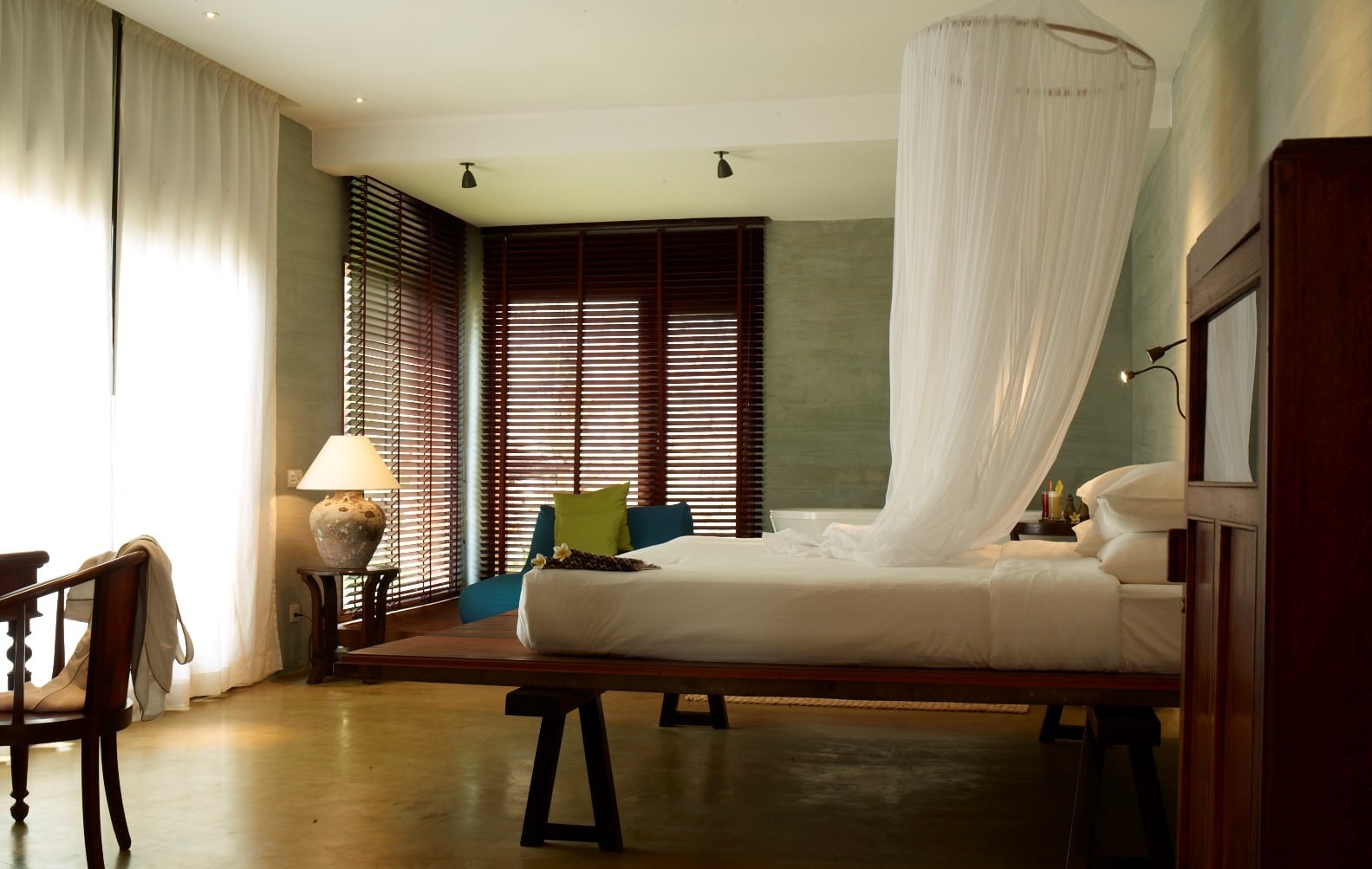 Minimalist luxury room at Knai Bang Chatt resort in Kep, Cambodia, featuring a floating canopy bed, natural textures, and ambient light – ideal for wellness and mindful retreats.