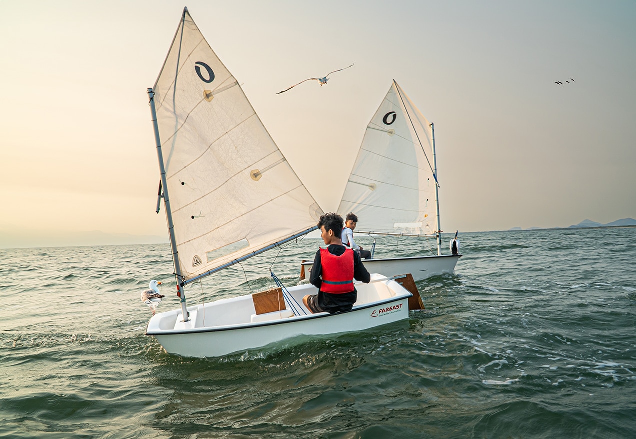 Guests learning to sail off the coast of Kep, Cambodia with Knai Bang Chatt’s Sail & Serenity retreat – where yoga meets ocean adventure.
