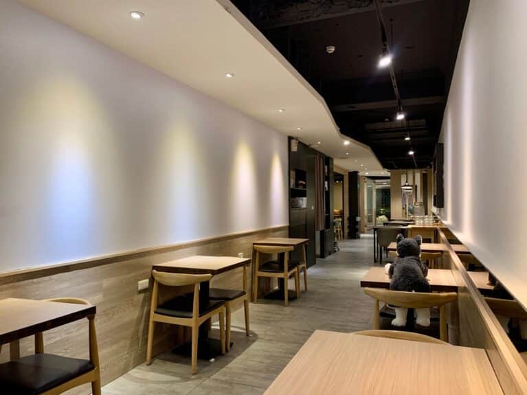 An empty coffee-shop room with tables.