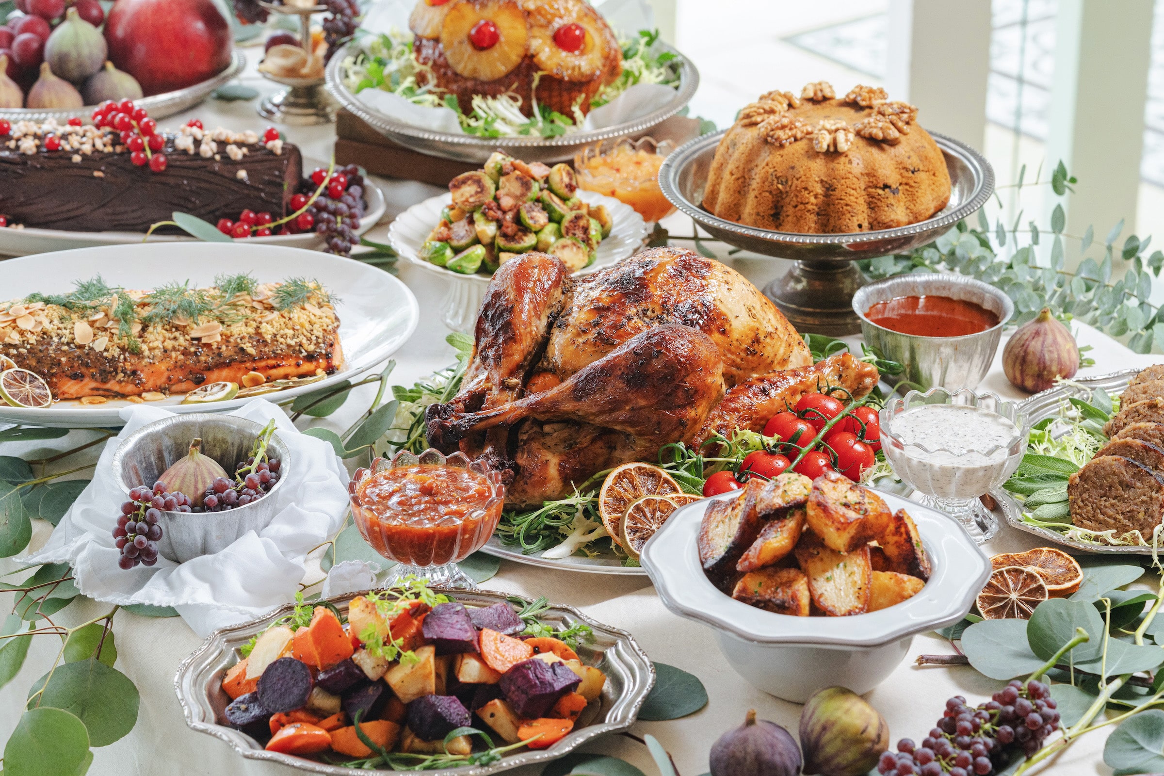 Elegant PS.Cafe Christmas feast spread with roasted turkey, honey-glazed ham, salmon, sides, and desserts styled. 