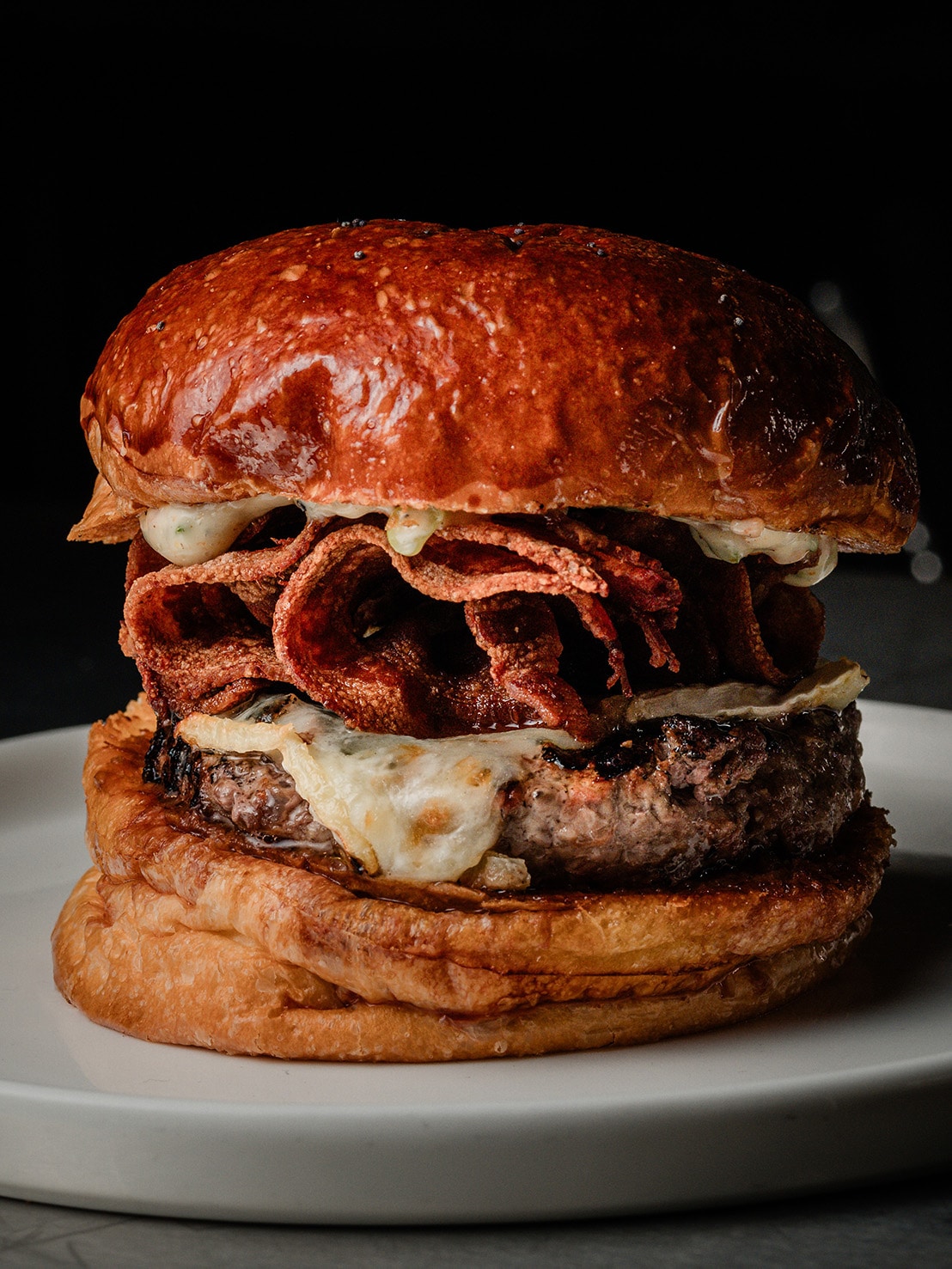 Triple bacon cheeseburger with grilled Wagyu beef patty, crispy bacon strips, and melted cheese on a toasted brioche bun