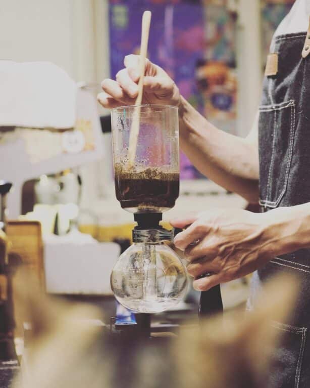 A barista doing a drip coffee brew.