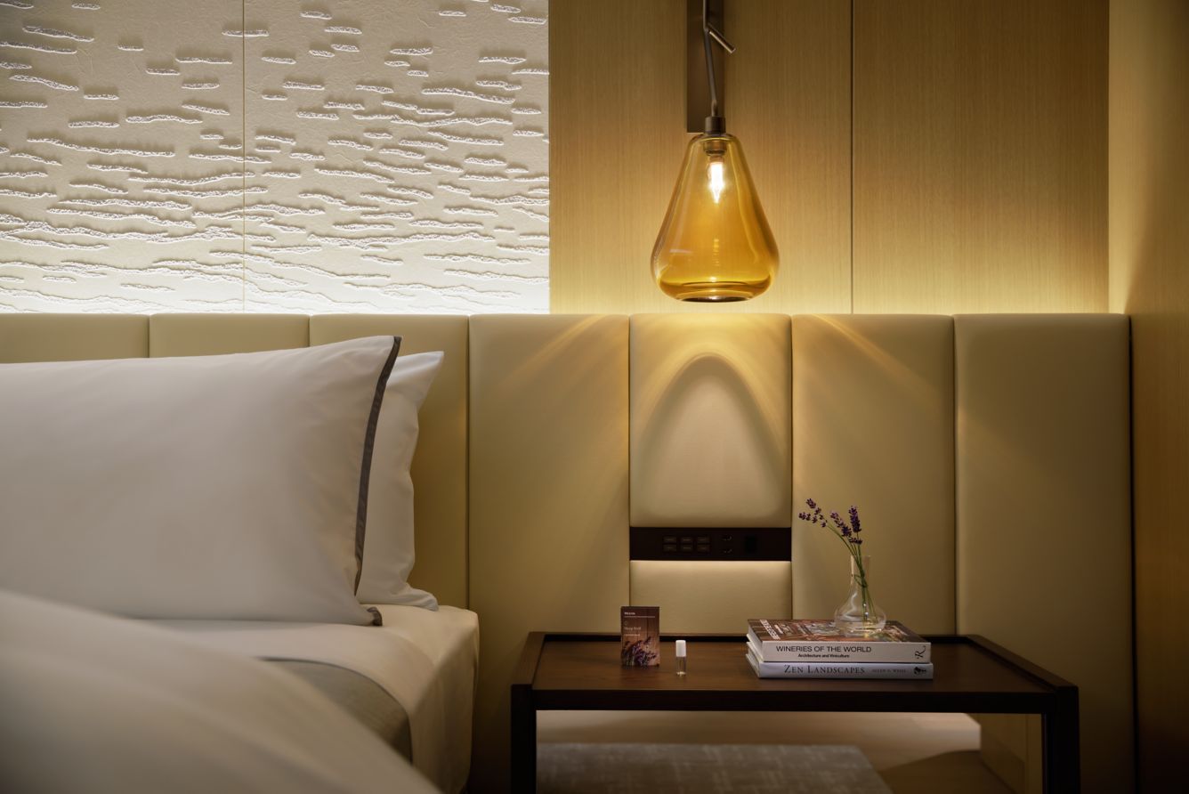 Close-up of The Westin Yokohama’s Heavenly® Bed with ambient lighting, lavender aromatherapy balm, and curated books—emphasising wellness and restful sleep.