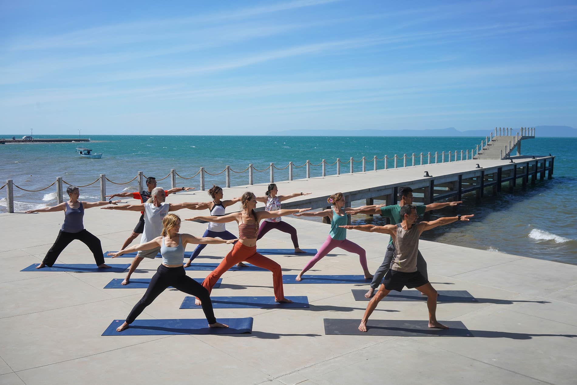 Group yoga session by the sea at Knai Bang Chatt resort in Kep, Cambodia – part of the resort’s regenerative wellness retreats and mindful travel offerings.