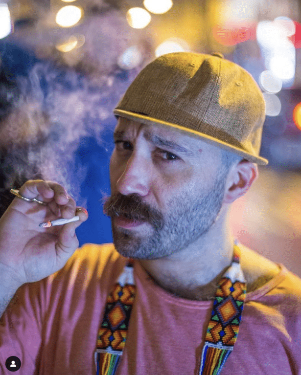 Nuno da Cruz, looking at camera, smoking a cigarrette.